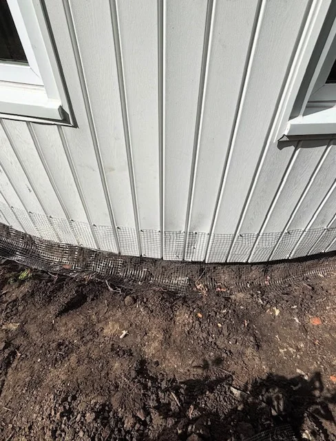 Metal mesh exclusion barrier installed at metal shed foundation and base